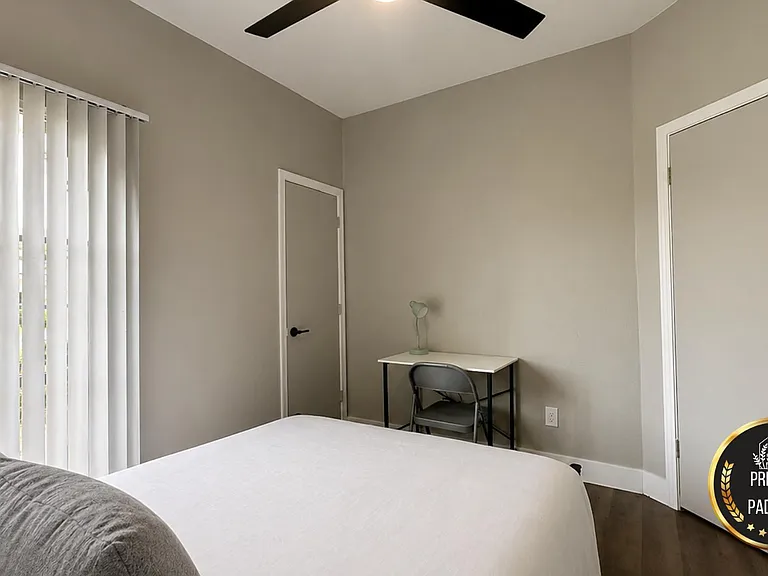Private bedroom with a large window, ceiling fan, and dedicated desk areaideal for studying or working from home.