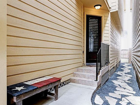 As you enter the front gate, you are greeted with a private entrance to 5516 Kiam St.  Tiled entry way with wrought iron hand rail and wrought iron detail on the front door.