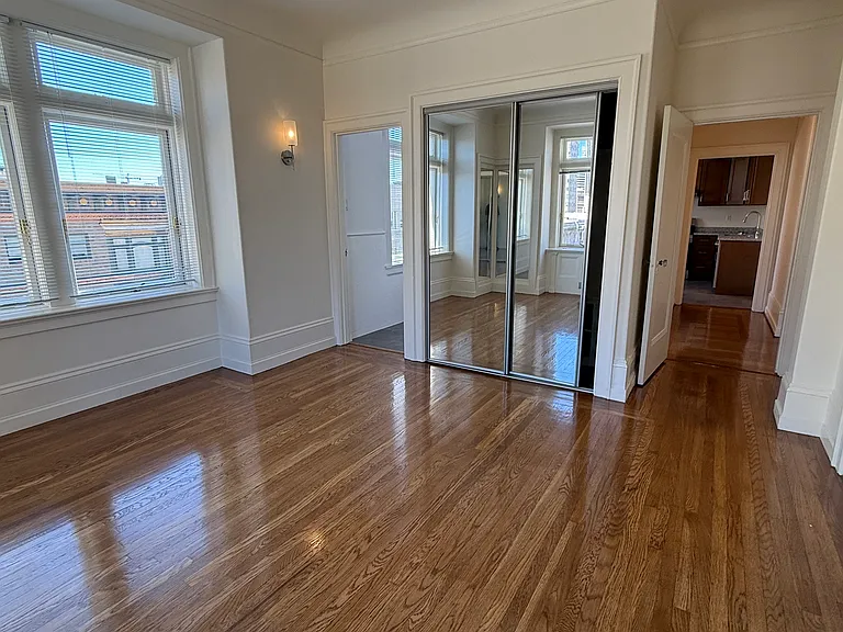 bedroom into bath (L) and kitchen (R) with mirrored closet doors