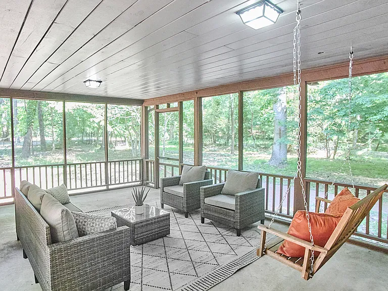 Screened porch looks into the back woods and provides a covered walk to the garage.