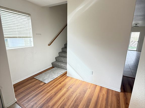 Entry flowing to stairwell, and living room to the right.