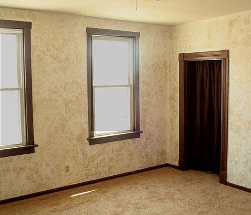 Spacious bedroom with high ceilings and fan.