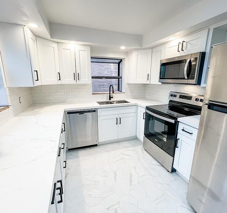 Newly remodeled kitchen! Bright and light with 2 windows and a skylight. View empty.