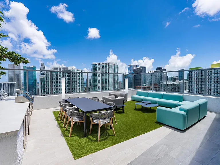 Dine and unwind with panoramic skyline views at Modera Riverside's rooftop outdoor lounge.