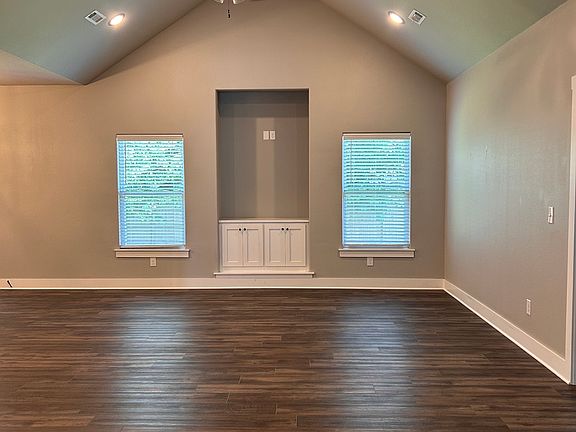 Living room. Vaulted ceilings, ceiling fan, and built in cabinets