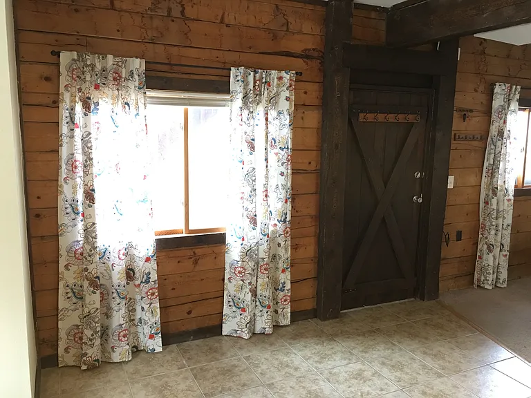 Living room with beamed ceilingl Lots of windows out to deck and fenced yard,