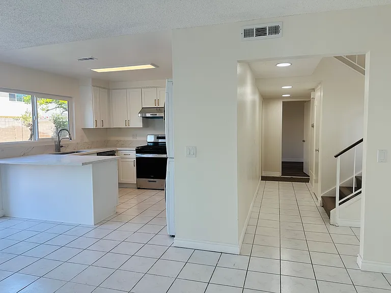Hallway showing Kitchen on the left side and first floor bedroom suite and bathroom on the right side