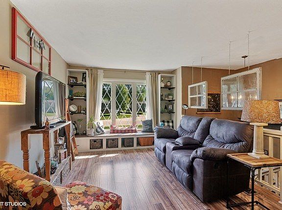 New engineered wood flooring and large window with built-in shelving add to the character of this ro