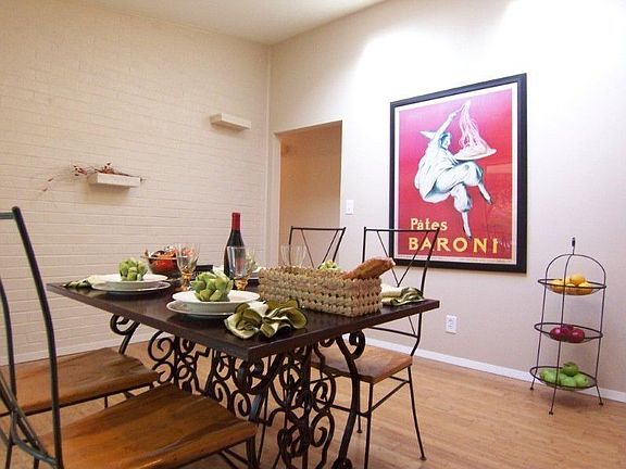 Open dining room with space for table, buffet and your favorite artwork; painted brick wall adds tex
