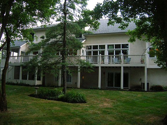 View of rear of home with large deck and paver patio beneath.  Three levels.