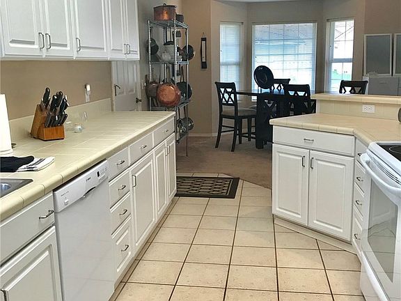 Viewing from kitchen toward dining area with vaulted ceiling. Tile counters and tile floor.  Light and bright.