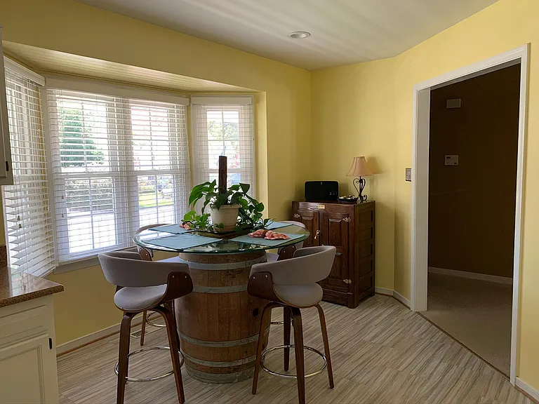 Eat-in kitchen. Flooring has been renovated with hardwood floor and walls repainted to a neutral color.
