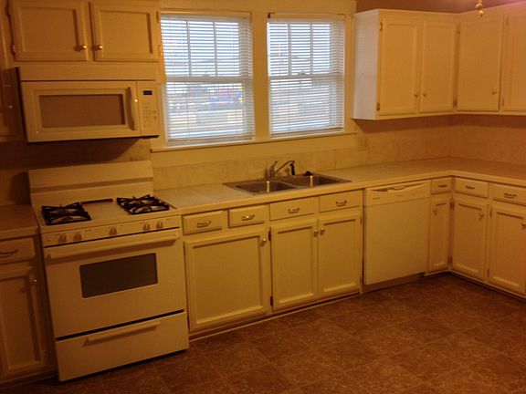 Kitchen with white cabinets/tile counters