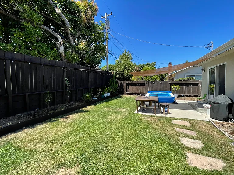 Backyard-Sun-drenched outdoor oasis featuring a lawn and a patio perfect for al fresco dining.