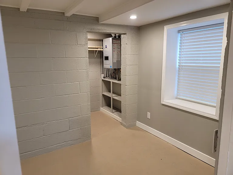 Front (2nd) bedroom, passage to closet. Tankless gas water heater showing -- unlimited hot water, high efficiency!