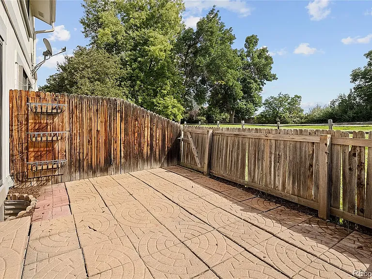 Back porch with stones and planter boxes. Backs up to HOA-maintained green belt and walking path.