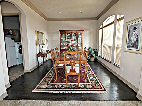 THE BEAUTIFUL FORMAL DINING ROOM WITH CROWN MOLDING FEATURES EASY ACCESS TO THE ISLAND KITCHEN.