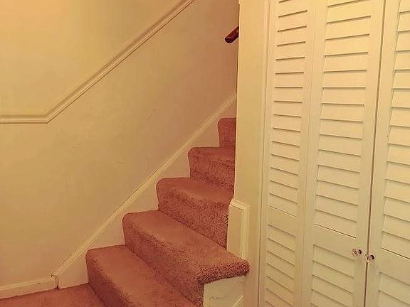 Entryway with storage closet and stairs to upper level.