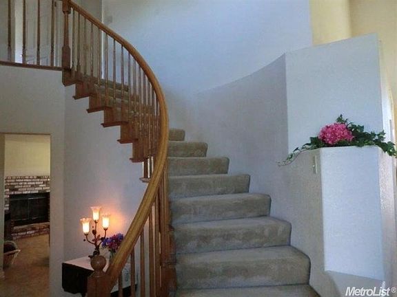 Lovely open spiral staircase with dÃ©cor shelving.