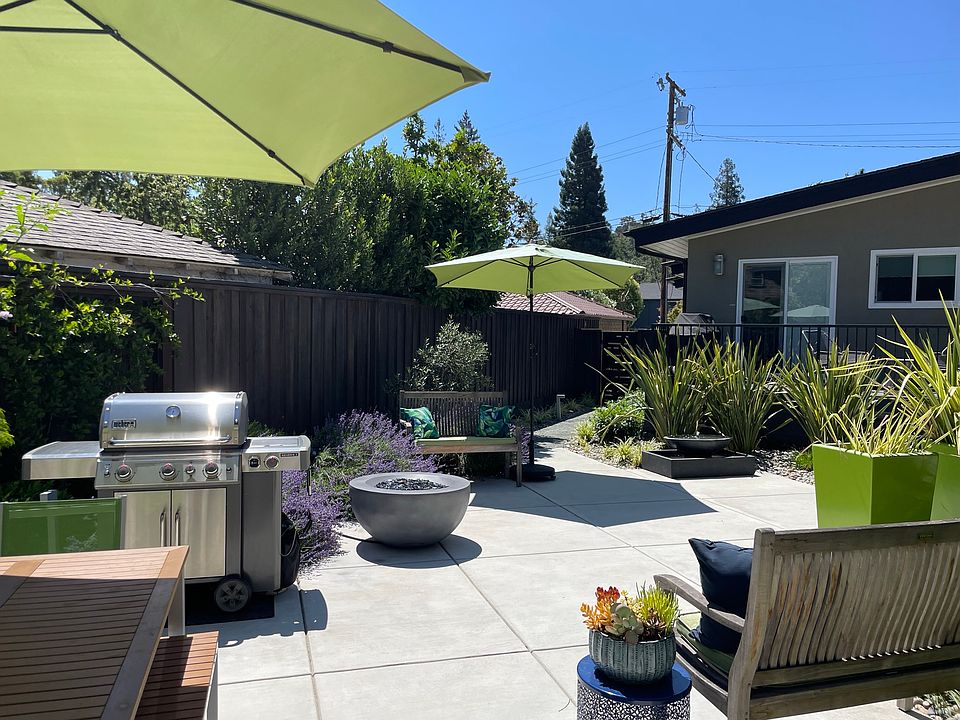 The Enclave at Chestnut Common Patio Area with Grill, Dining Table for 6, Firepit and Fountain lushly landscaped