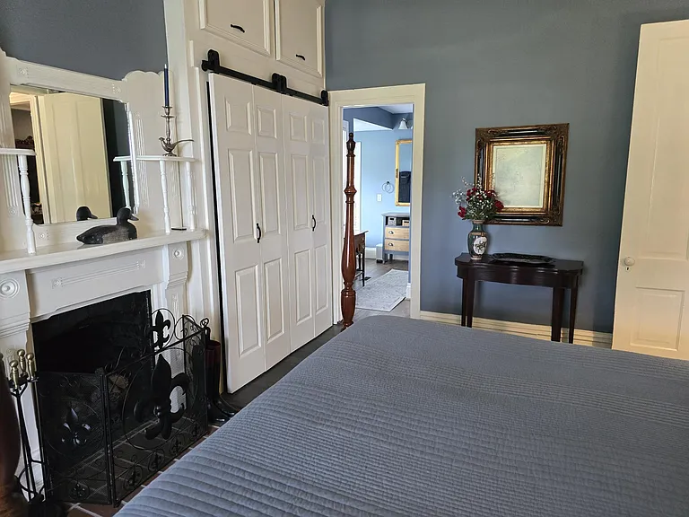 View of master bath suite from corner of primary bedroom: pocket doors located in doorway and close for privacy.