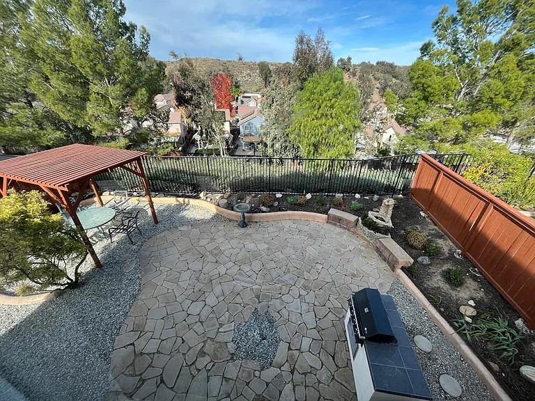 Large, fully landscaped rear yard with pergola, gas BBQ, and stunning views.