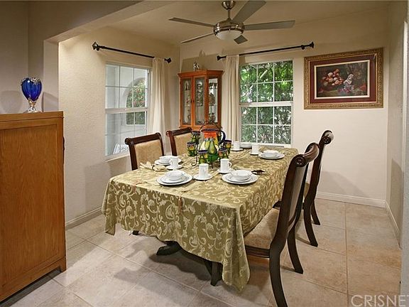 The elegant formal dining room with lovely outdoor views and lighted ceiling fan is perfect for any occasion.