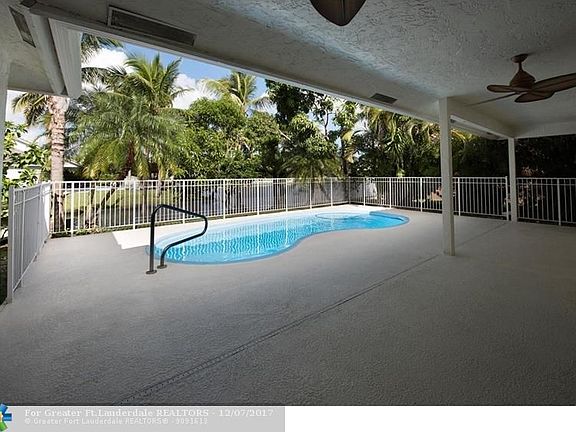 Fiberglass pool surrounded by cool deck, with canal and lake views