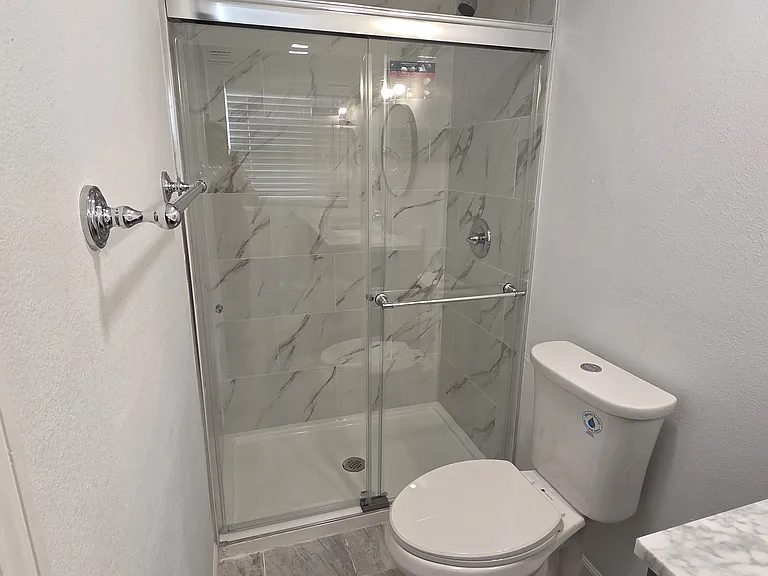 Modern, clean shower with plenty of space, towel racks and fresh towels.