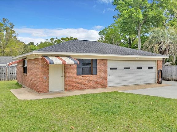Ranch-style house featuring brick siding, concrete driveway, roof with shingles, and an attached garage