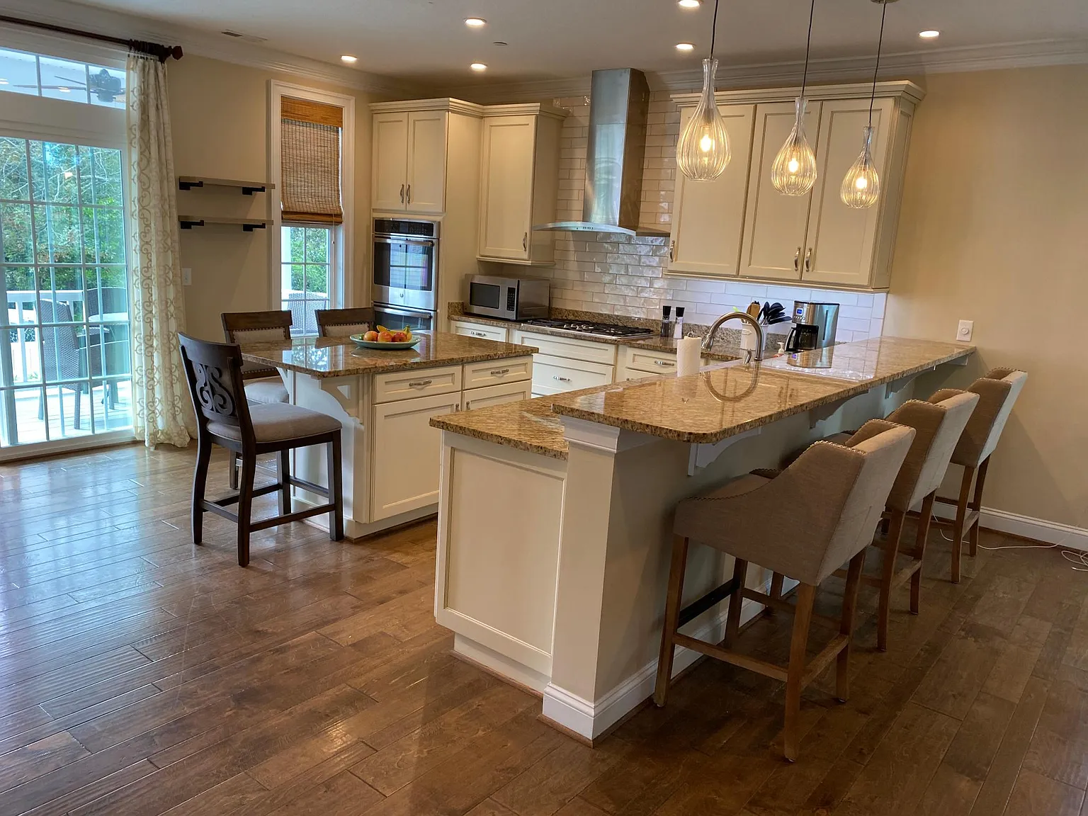 View from living area. Double oven, microwave, gas stove with 5 burners, double door refrigerator with freezer at bottom, plenty of storage.