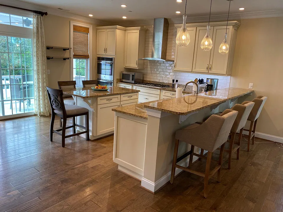 View from living area. Double oven, microwave, gas stove with 5 burners, double door refrigerator with freezer at bottom, plenty of storage.