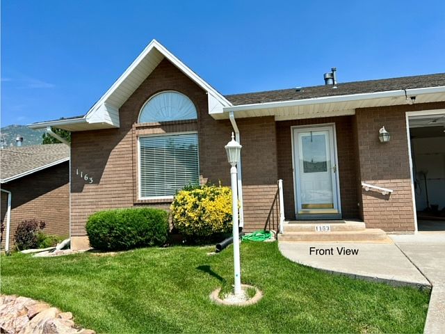 Front view of home. Glass or screened storm door with lock. Two car garage with attic fan.