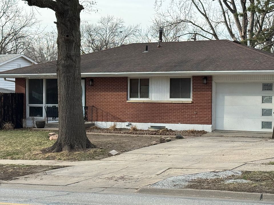 The house has an attractive brick exterior, with several mature oak trees.