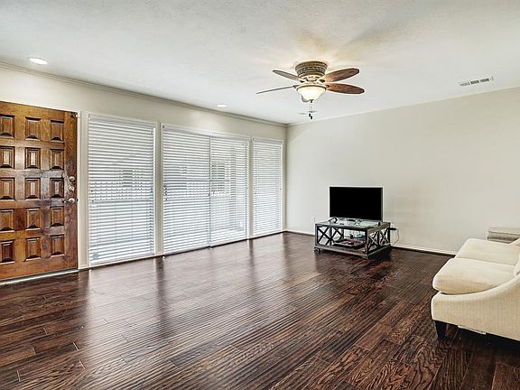 Living area with hardwoods, recessed lighting and views of front entrance.