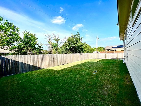 Large back yard with tree cover to the property behind