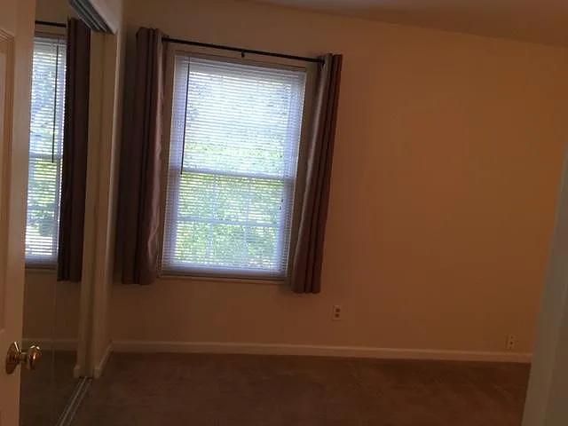Master bedroom with mirrored closet.