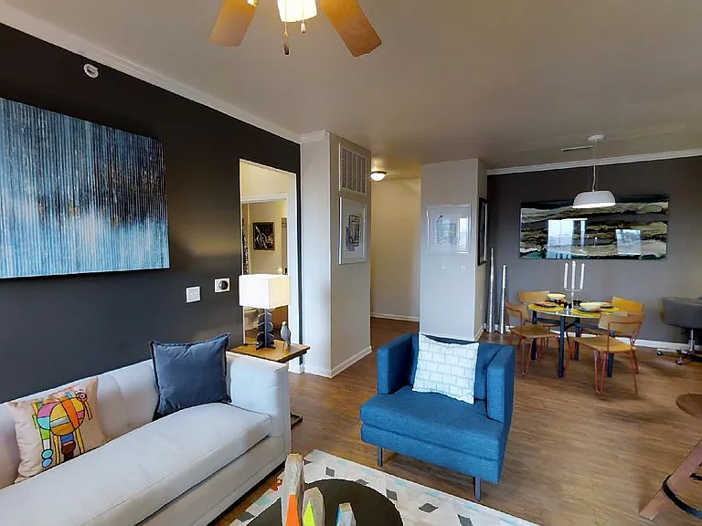 Apartment kitchen, dining and living room with wood-style flooring.