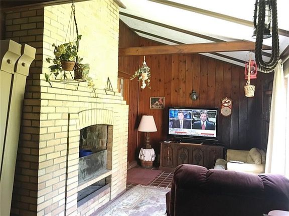 FAMILY ROOM - Wood burning brick fireplace to curl around on those chilly days.  Clay tile floors and cedar panels.  Slider to t