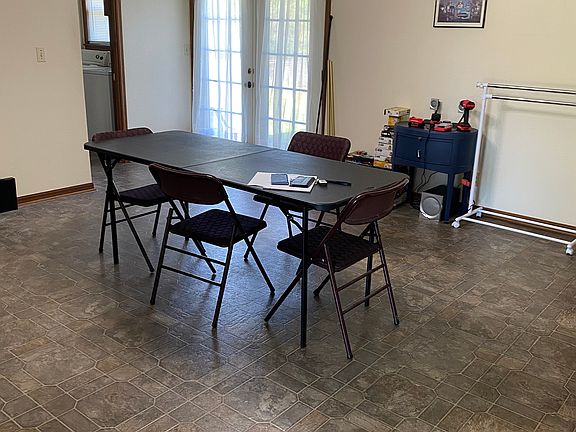 Dining area looking at patio doors to fenced back yard with utility room to the left.
