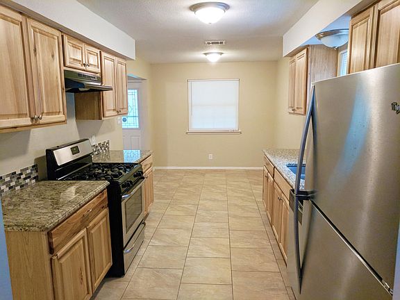 Kitchen boasts stainless steel refrigerator and dishwasher, 
