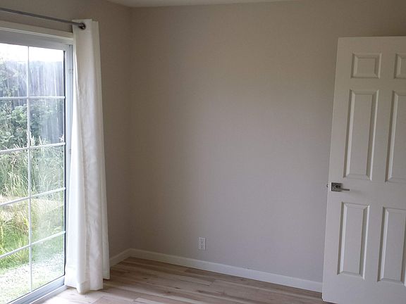 The bedroom has a sliding door leading out to the private fenced yard.