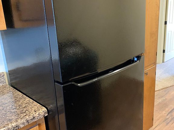 Brand new Black Frigidaire appliances with refrigerator, dishwasher, stove.
