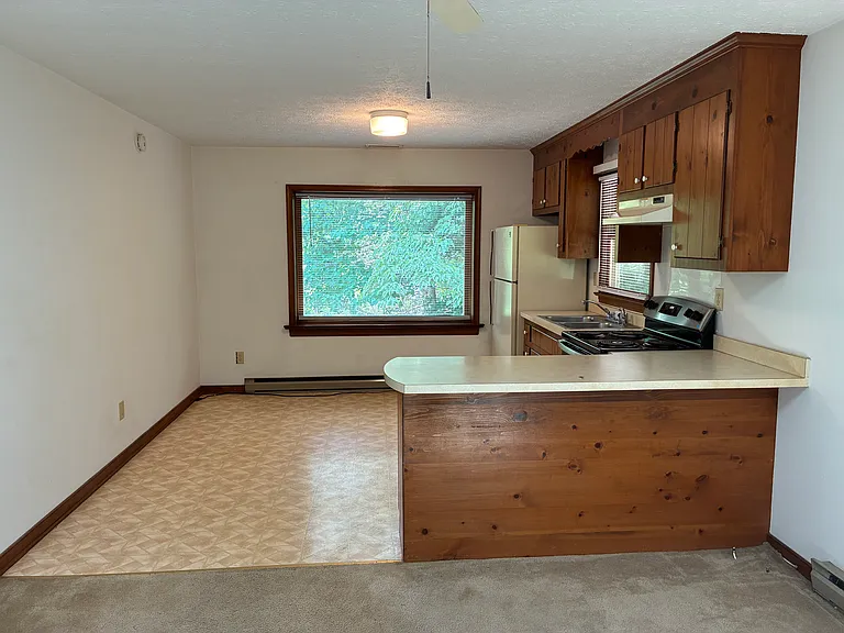 The great room with picture window combining living, dining and kitchen