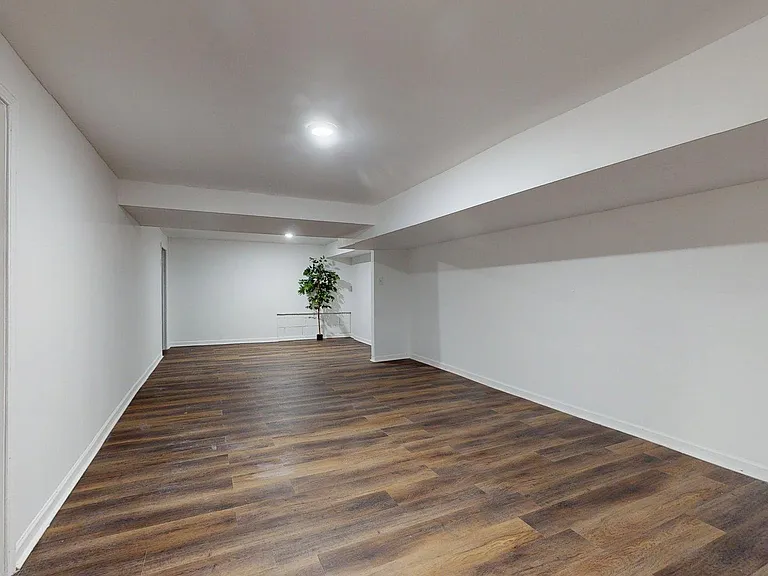 Spacious open flex room with durable wood-look flooring and recessed lightingideal for a lounge, office, or workout area.