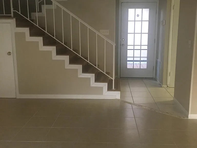 Living area, view of stairs to 2nd Floor and entrance from c