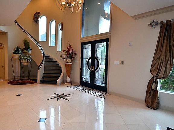 Entry to the home with stunning floors, high ceilings and spiral staircase.