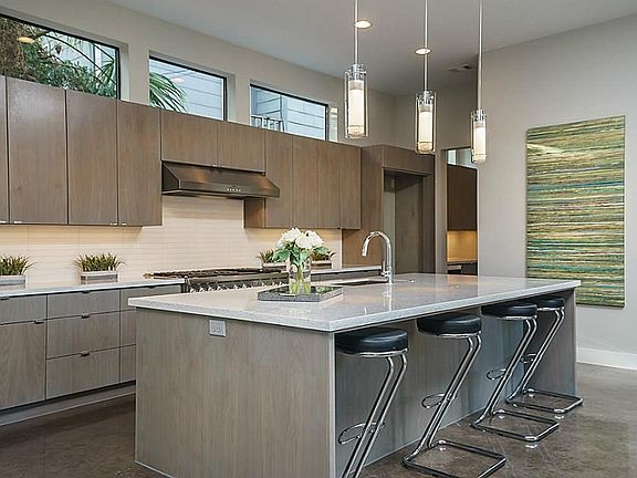 The kitchen offers beautiful quartz countertops and custom built walnut cabinets.