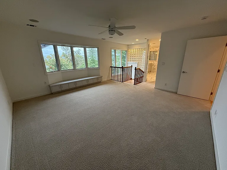 Primary suite features a sitting bay window and a spiral staircase leading down to an exercise studio.