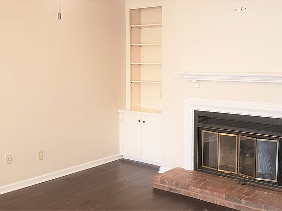 Living room with builtin bookcase and storage and a fireplace.